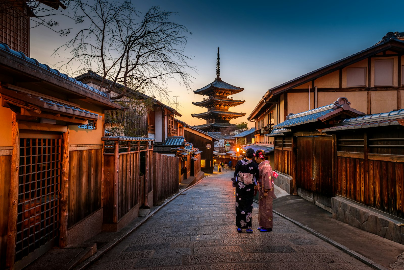 A lantern-lit street in Kyoto below a pagoda